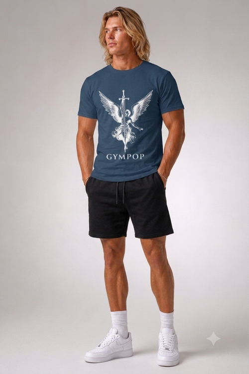 A man modeling a navy blue t-shirt with a white winged medical symbol and the word 'GYMPOP' printed on the front, paired with black shorts, white socks, and white sneakers against a light gray studio background.