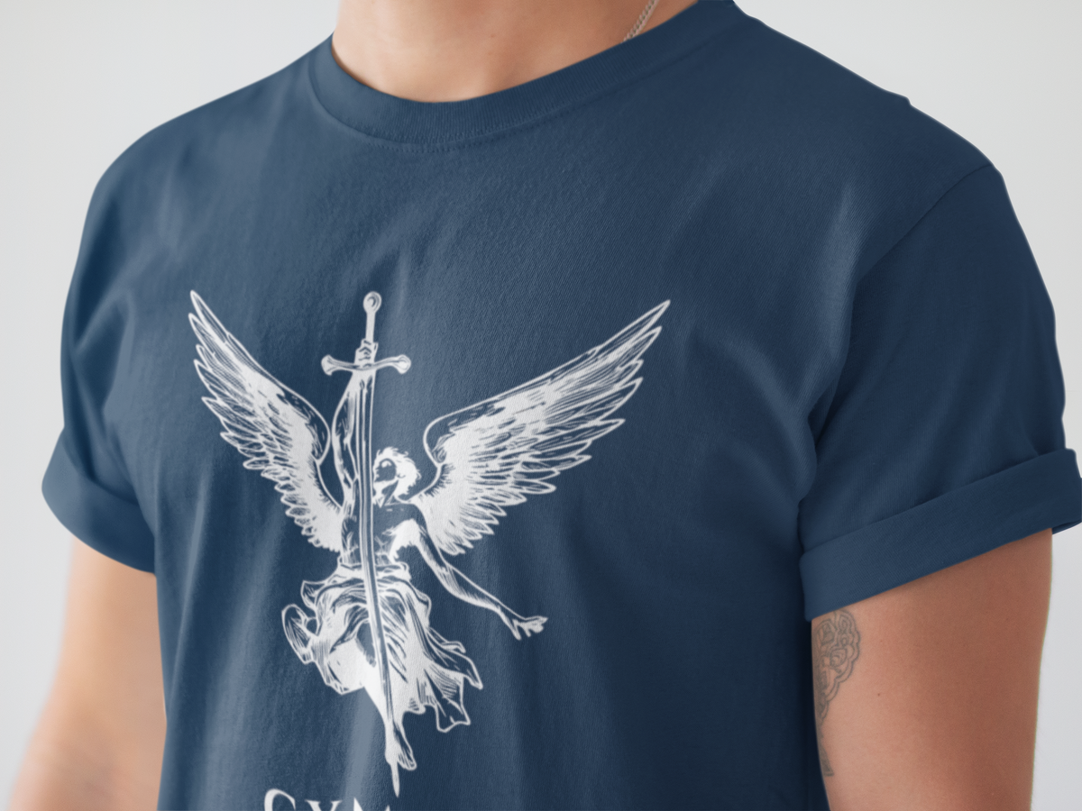 A close-up of a person wearing a navy blue t-shirt with a white graphic of an angel with wings and a sword, holding a banner that reads GYMPOP