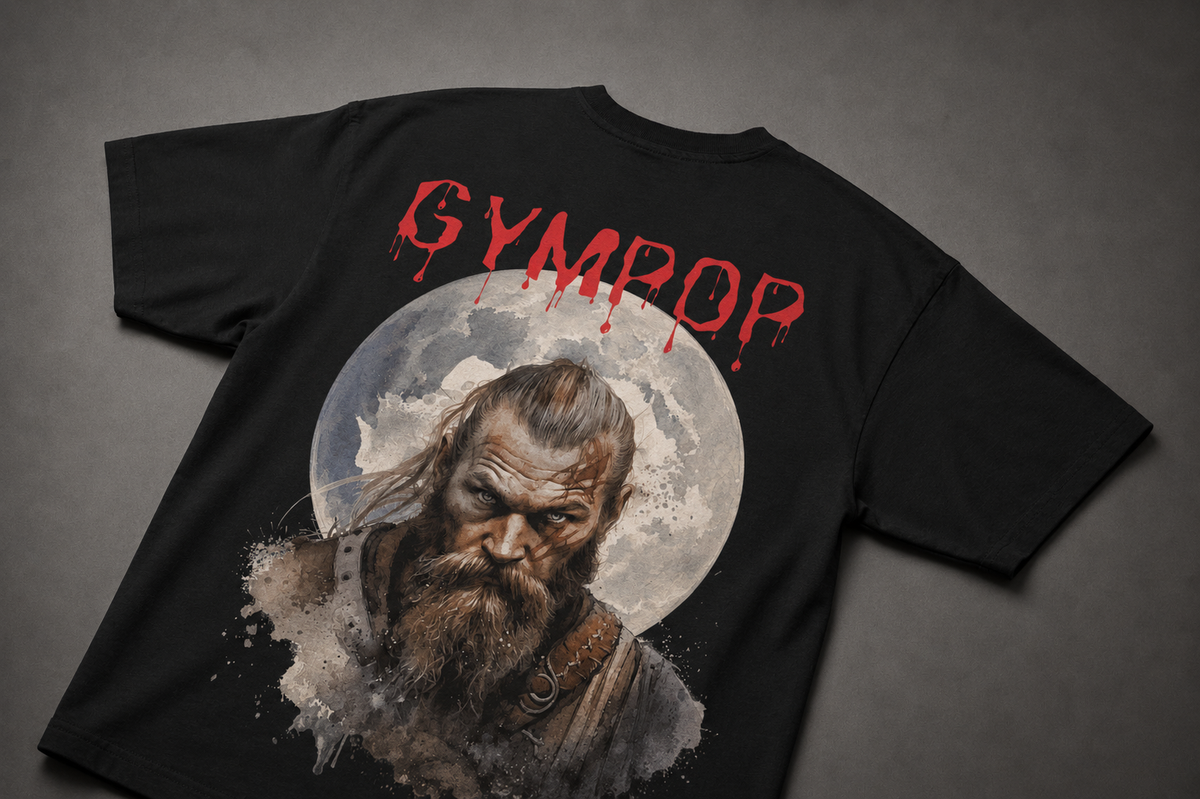 A black short-sleeve t-shirt laid flat on a dark grey textured background, featuring a large graphic print of a bearded Viking man in front of a moon with the word 'GYMPROP' in dripping red letters above.